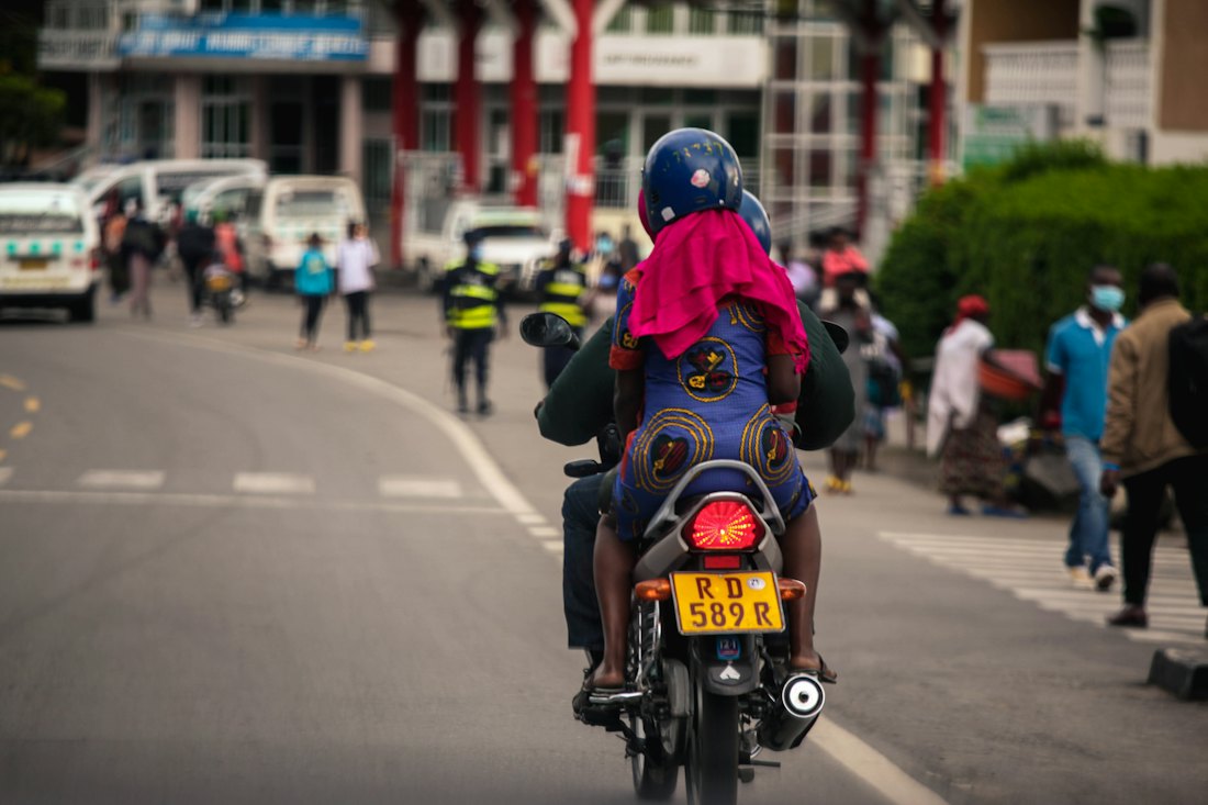 A motorcycle courier riding through city traffic