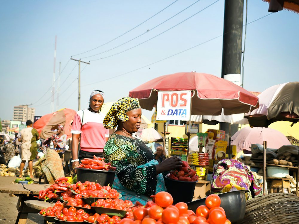 A trader pushing a loaded cart through a Lagos market