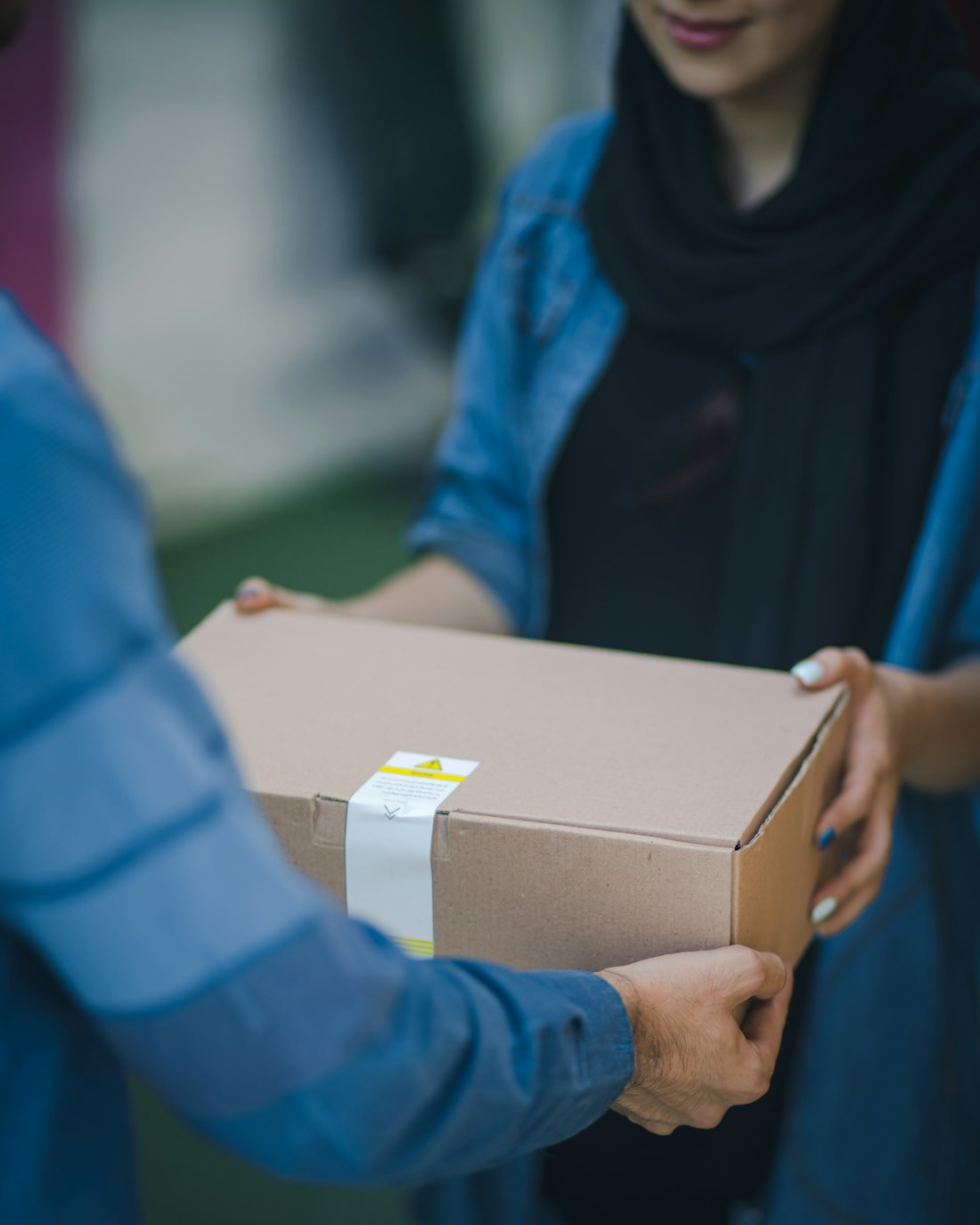 One person handing a parcel to another